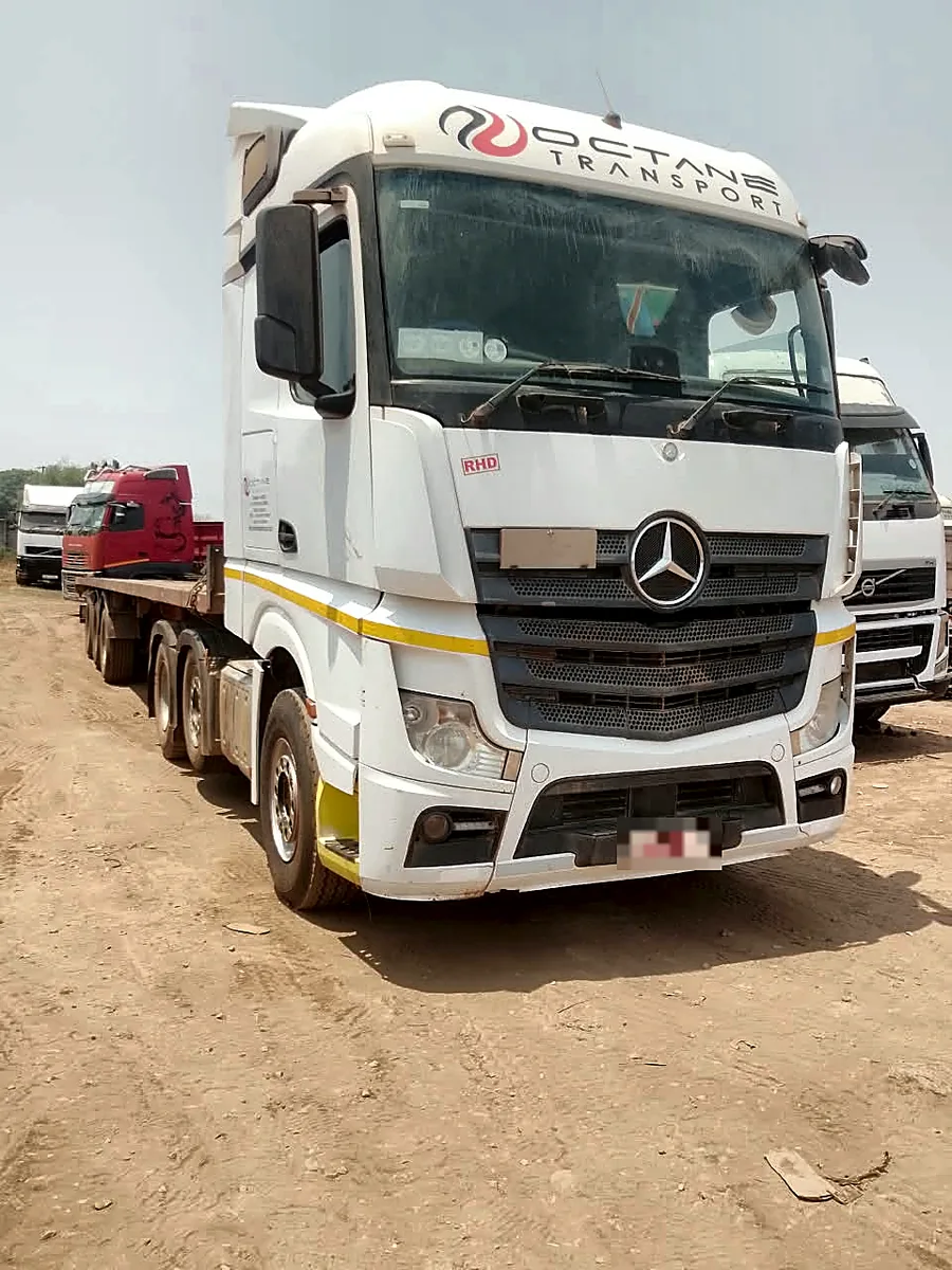 Octane Transport Mercedes-Benz Actros hitched to a tri-axle flatbed trailer, seen from the front